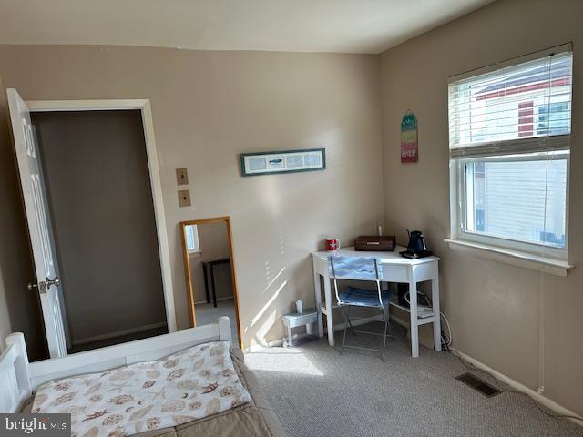 carpeted bedroom featuring visible vents