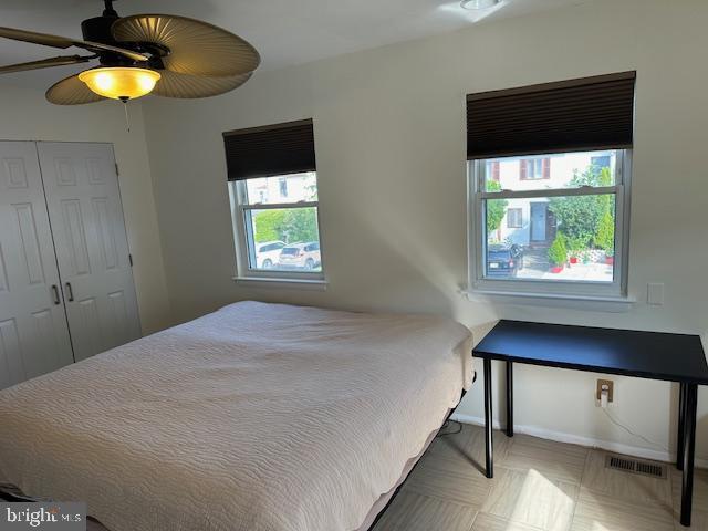 bedroom with a ceiling fan, a closet, visible vents, and baseboards