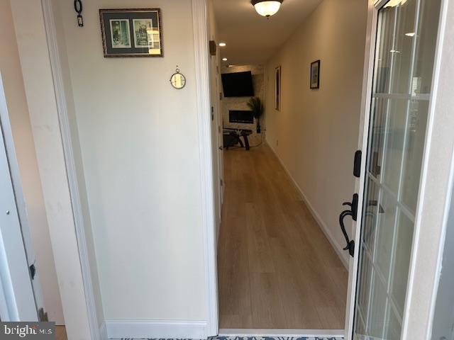 hall with baseboards and wood finished floors