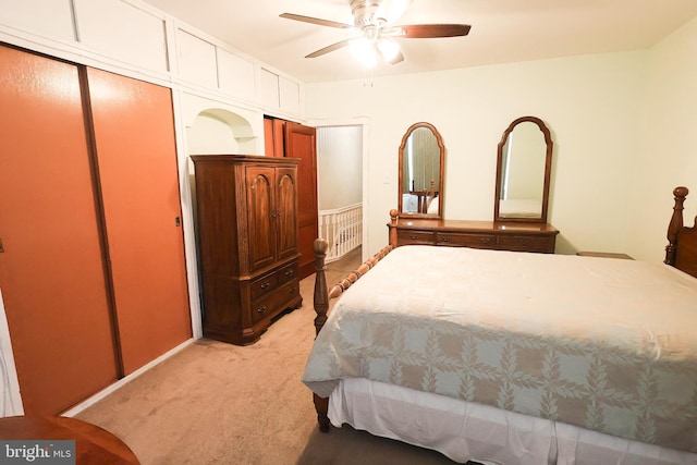 bedroom featuring light carpet, a ceiling fan, and a closet