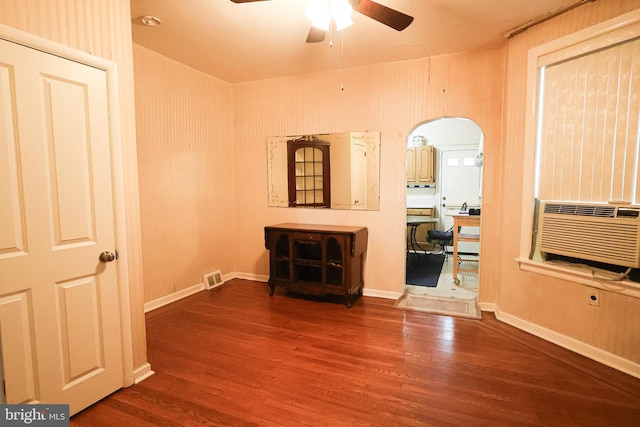 unfurnished room featuring arched walkways, wood finished floors, visible vents, and a ceiling fan