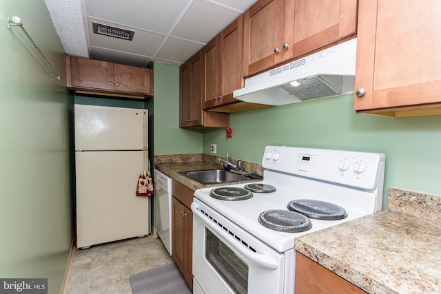 kitchen with under cabinet range hood, visible vents, a sink, white appliances, and brown cabinetry