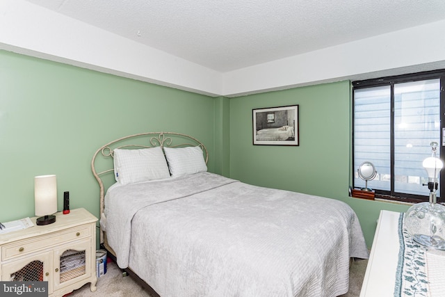 bedroom with multiple windows, carpet, and a textured ceiling