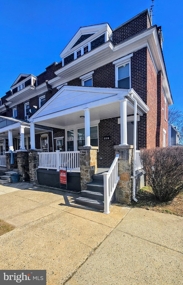 view of front of house with brick siding and a porch