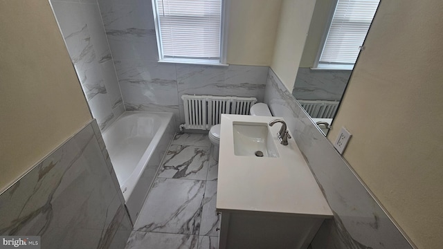 full bathroom featuring toilet, vanity, marble finish floor, a bath, and radiator