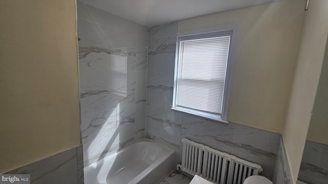 full bath with marble finish floor and radiator heating unit