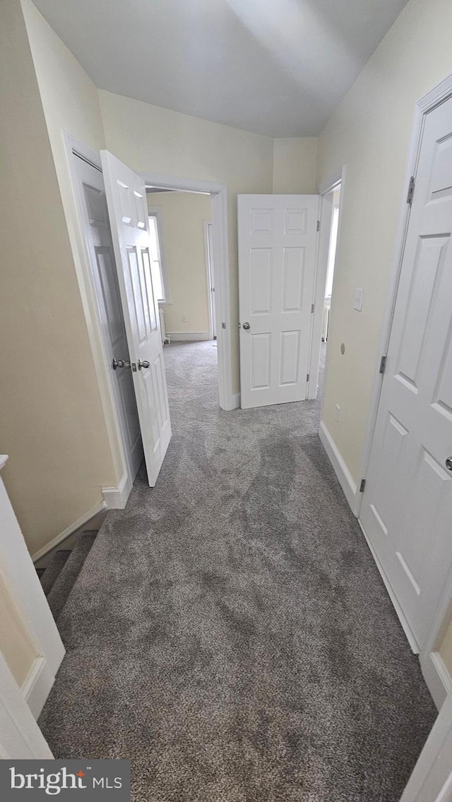 hall featuring carpet and baseboards