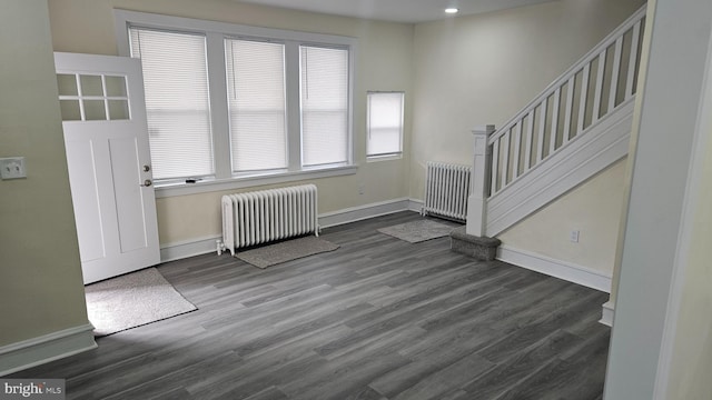 interior space featuring stairway, radiator heating unit, wood finished floors, and baseboards