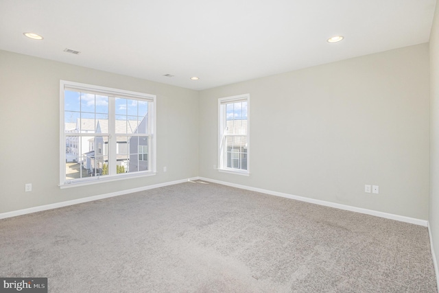 unfurnished room with visible vents, recessed lighting, carpet flooring, and baseboards