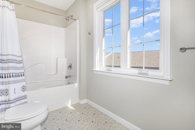 full bath featuring tile patterned floors, toilet, shower / tub combo, and baseboards