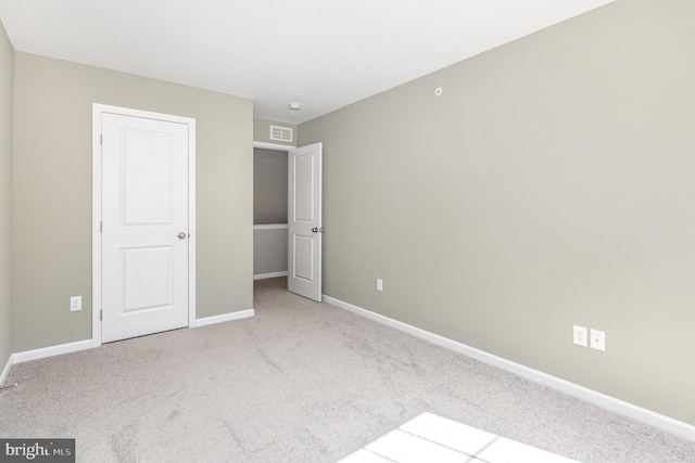 unfurnished bedroom with carpet flooring, baseboards, and visible vents