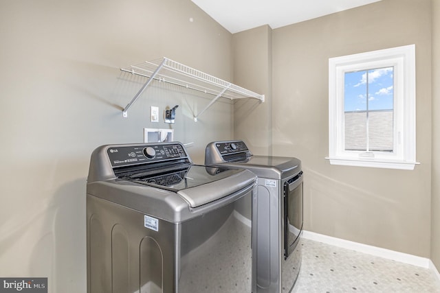 laundry room featuring baseboards, laundry area, and washer and clothes dryer