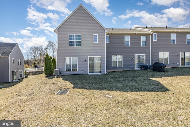 rear view of property featuring cooling unit and a yard