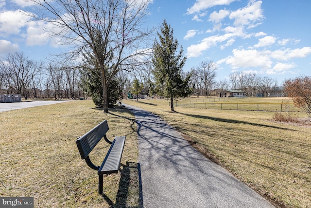 view of home's community featuring a lawn and fence