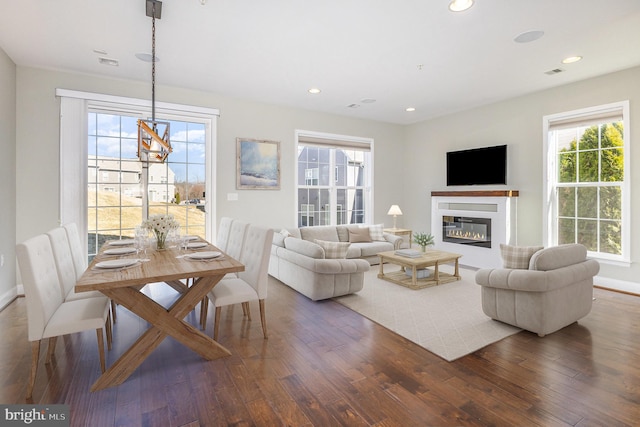 living room featuring visible vents, baseboards, recessed lighting, wood finished floors, and a glass covered fireplace