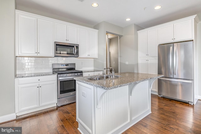 kitchen featuring a sink, tasteful backsplash, dark wood finished floors, white cabinetry, and appliances with stainless steel finishes