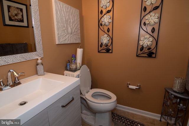 bathroom featuring baseboards, vanity, toilet, and tile patterned floors