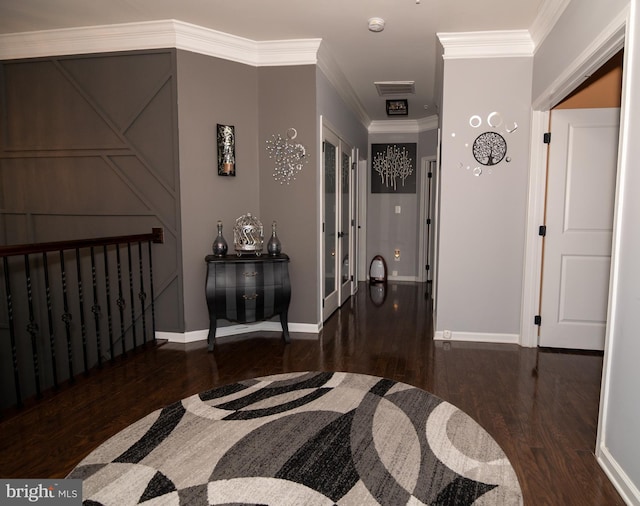 hallway featuring visible vents, crown molding, baseboards, and wood finished floors