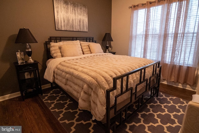 bedroom with dark wood-style floors and baseboards