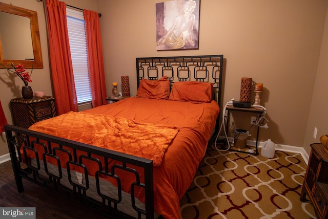 bedroom with baseboards and wood finished floors