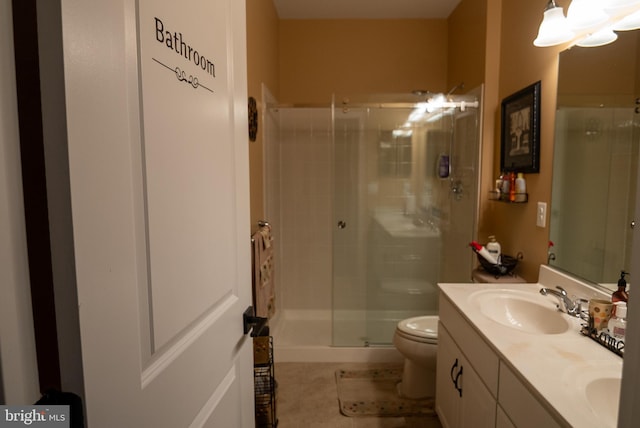 full bathroom with double vanity, a sink, toilet, and a shower stall