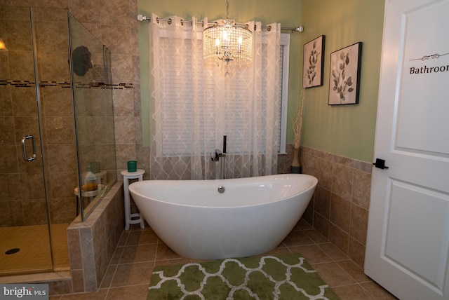 full bath featuring a stall shower, a freestanding bath, tile walls, and tile patterned floors