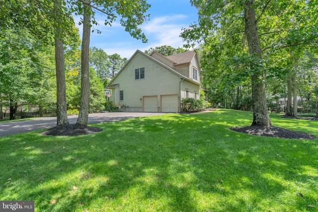 view of home's exterior with aphalt driveway, a yard, and an attached garage