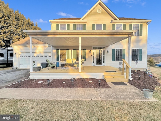 rear view of property with a garage and aphalt driveway