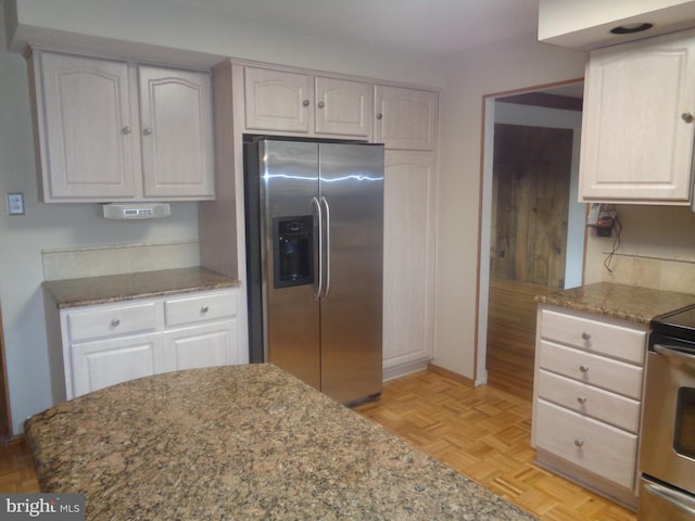 kitchen featuring stainless steel appliances, stone counters, and white cabinets