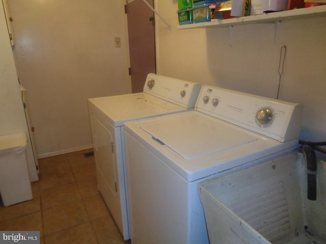 laundry area featuring tile patterned flooring, laundry area, baseboards, and separate washer and dryer