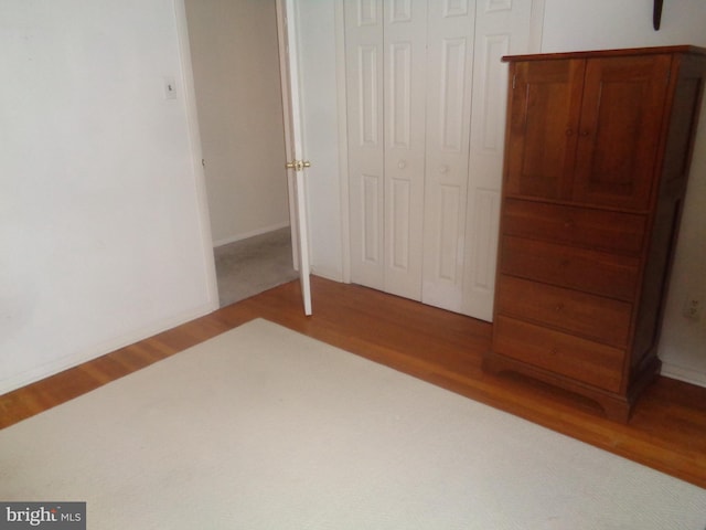 unfurnished bedroom featuring a closet and wood finished floors