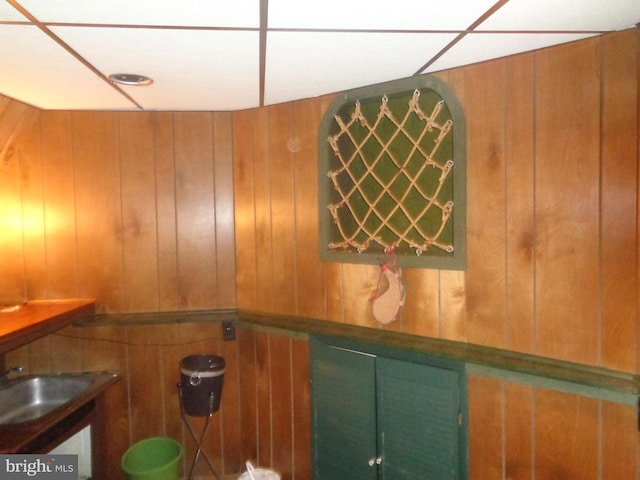 interior details featuring a bar, wood walls, and a sink