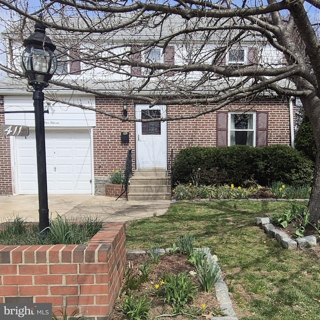 view of front of property featuring entry steps, a garage, brick siding, and concrete driveway
