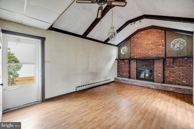 unfurnished living room with a baseboard heating unit, ceiling fan, vaulted ceiling with beams, a fireplace, and wood finished floors