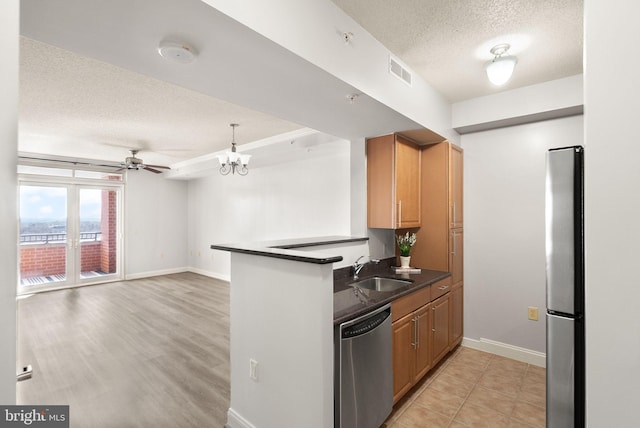 kitchen with dark countertops, visible vents, appliances with stainless steel finishes, a sink, and a textured ceiling