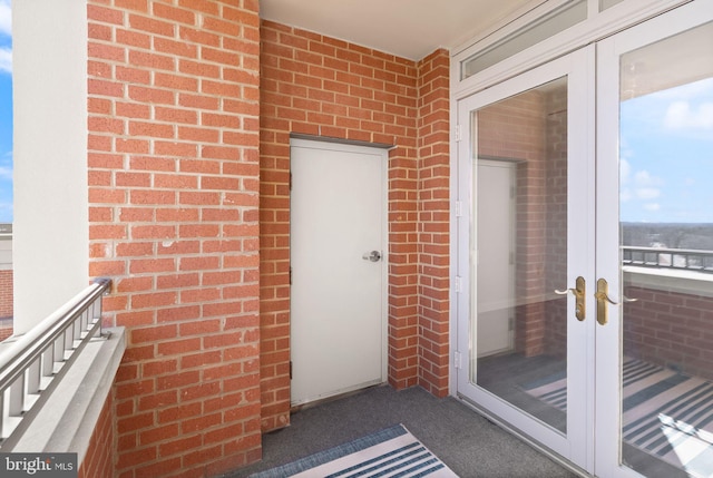 view of exterior entry with french doors and brick siding