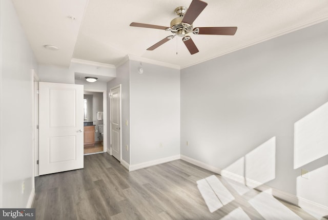 empty room featuring baseboards, ornamental molding, and wood finished floors