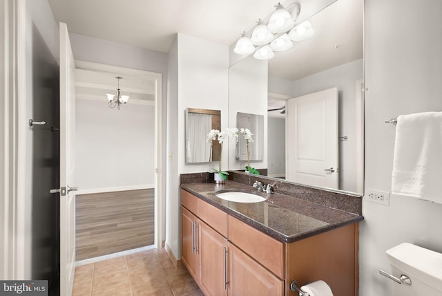 bathroom with toilet, vanity, baseboards, and tile patterned floors