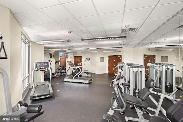exercise room with a drop ceiling and visible vents