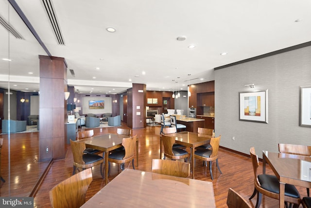 dining room with wood finished floors, decorative columns, and recessed lighting