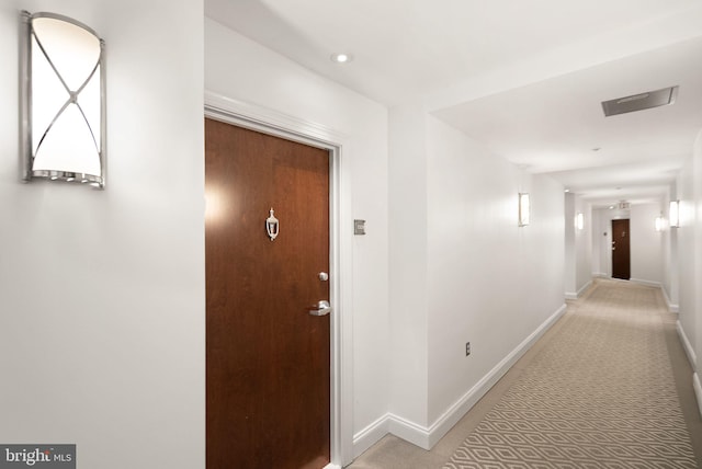 corridor featuring light carpet, baseboards, and recessed lighting