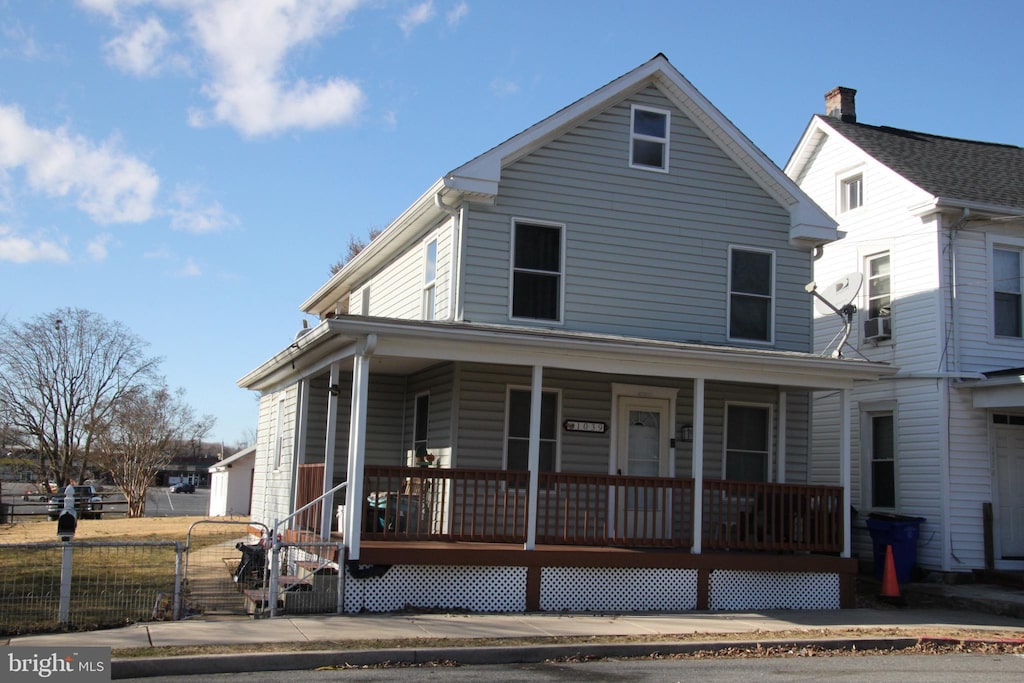 view of front of property with covered porch and fence