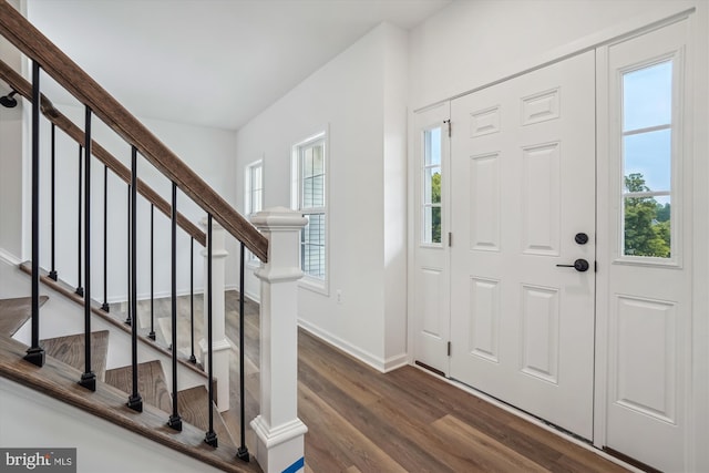 entrance foyer featuring baseboards, stairway, and dark wood finished floors