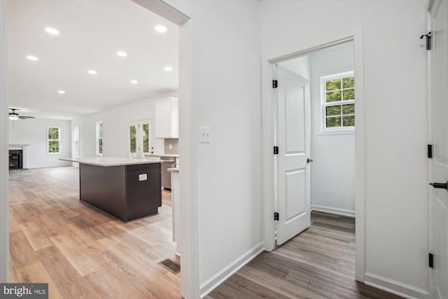 corridor with recessed lighting, visible vents, light wood-style flooring, and baseboards