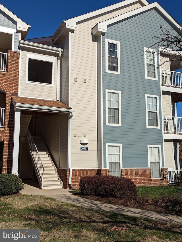 view of front of house with brick siding and stairs