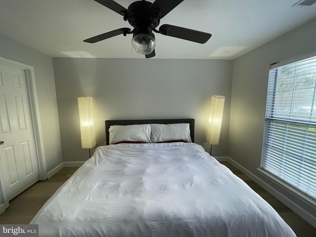 bedroom featuring visible vents, ceiling fan, baseboards, and wood finished floors