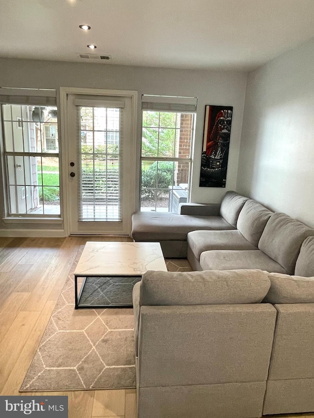 living room featuring wood finished floors, visible vents, and recessed lighting