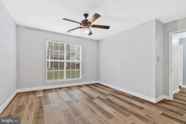 unfurnished room with ceiling fan, baseboards, and wood finished floors