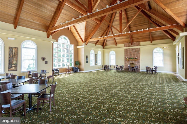 misc room featuring a brick fireplace, wood ceiling, baseboards, and high vaulted ceiling