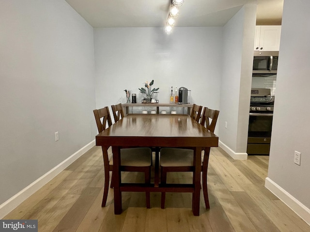 dining room featuring light wood-type flooring and baseboards